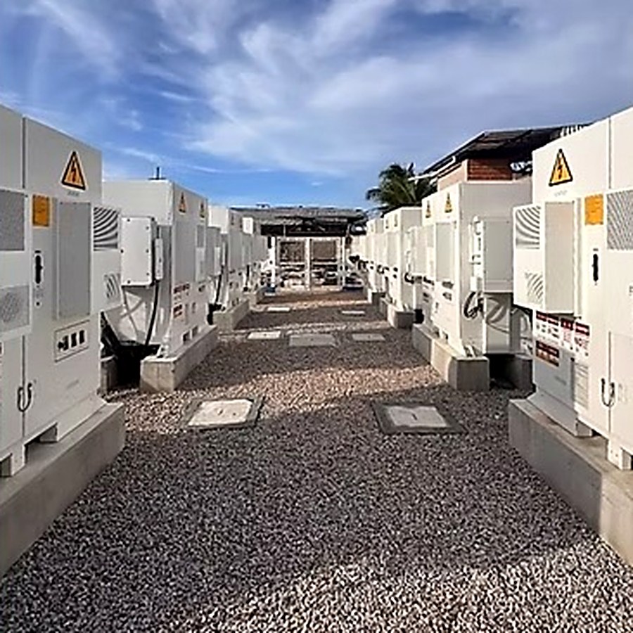 Corredor entre contêineres de baterias e inversores de uma usina